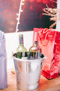 Close-up of an ice bucket filled with chilled bottles of wine and champagne, surrounded by festive decorations.