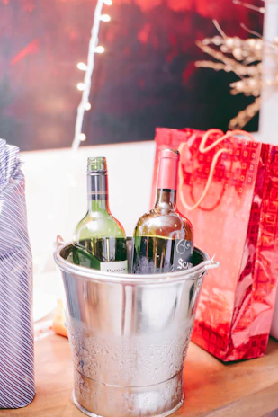 Close-up of an ice bucket filled with chilled bottles of wine and champagne, surrounded by festive decorations.