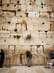 A serene photo of the Western Wall with a small note tucked between the stones