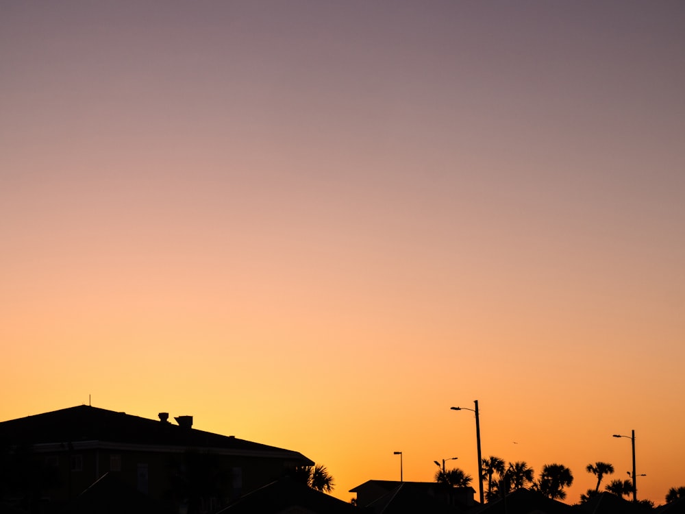 silhouette of house and trees during sunset