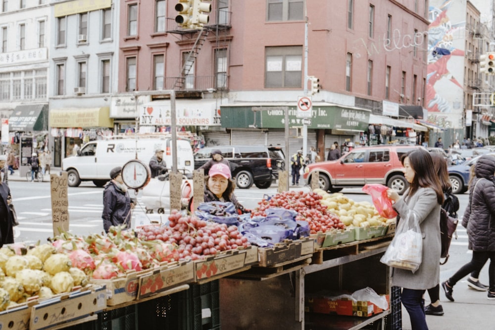 woman in grey long-sleeved shirt standing near vegetables