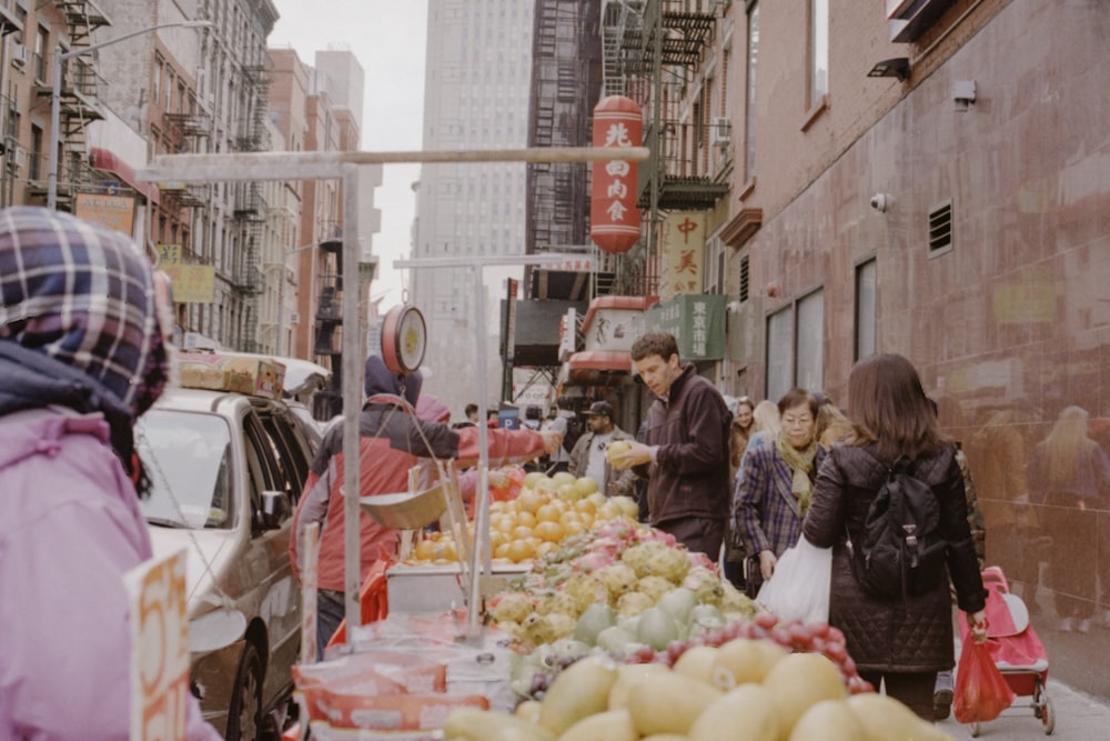 people in fruit stands beside building