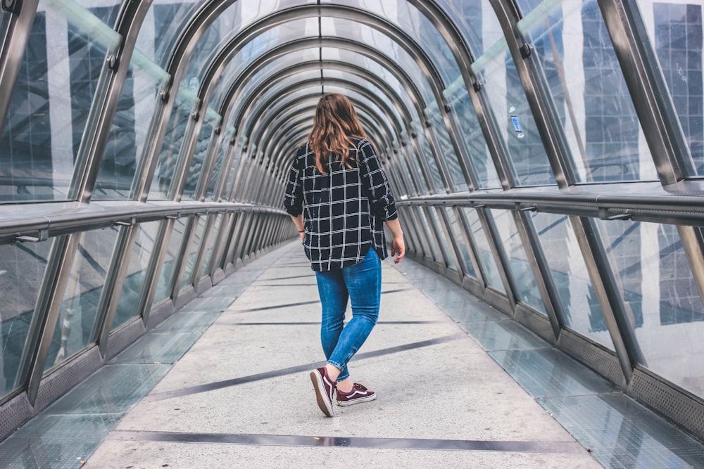 woman standing inside glass arch pathway