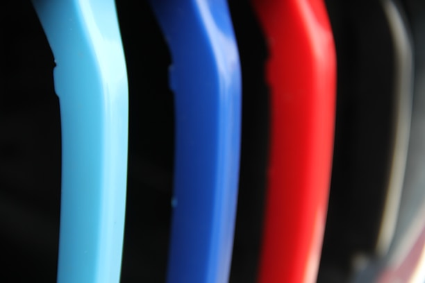 A close-up of sleek, non-slip hangers holding various colorful clothes in a bright, organized closet.