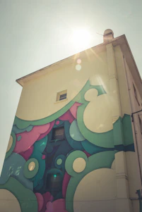 A cheerful artist painting a colorful mural on a storefront window during golden hour.