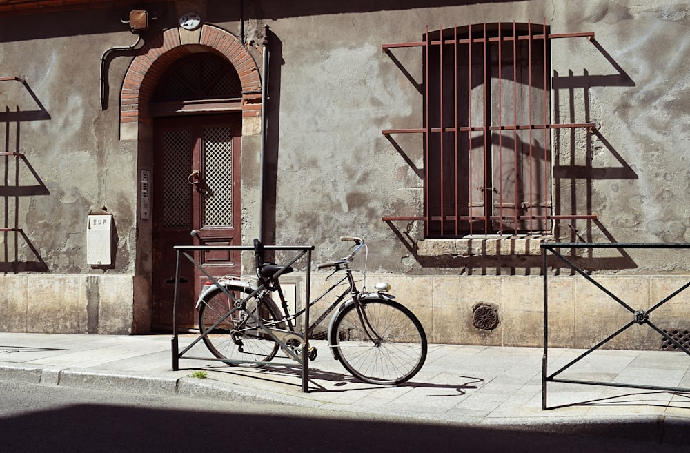 Bicicleta cinza da cidade estacionada na calçada