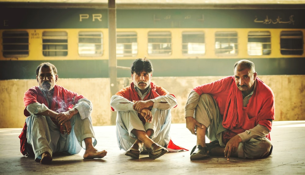 three men sitting on floor