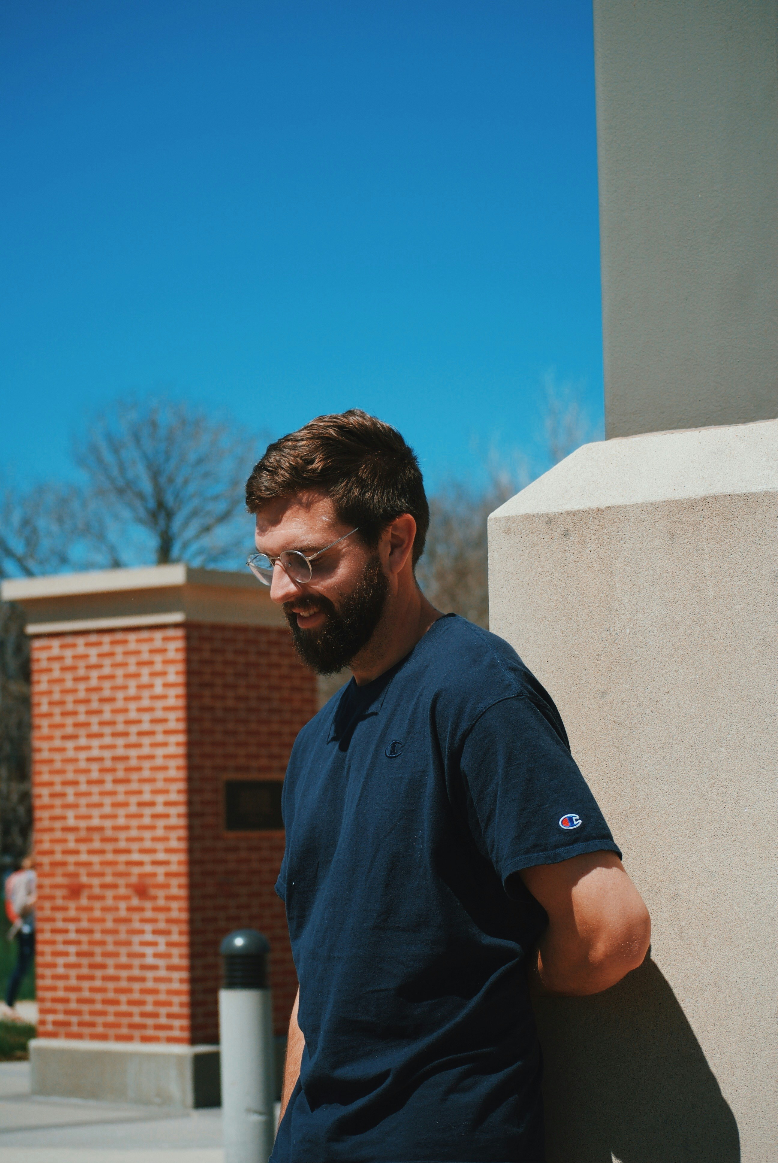 man looking at road leaning on wall
