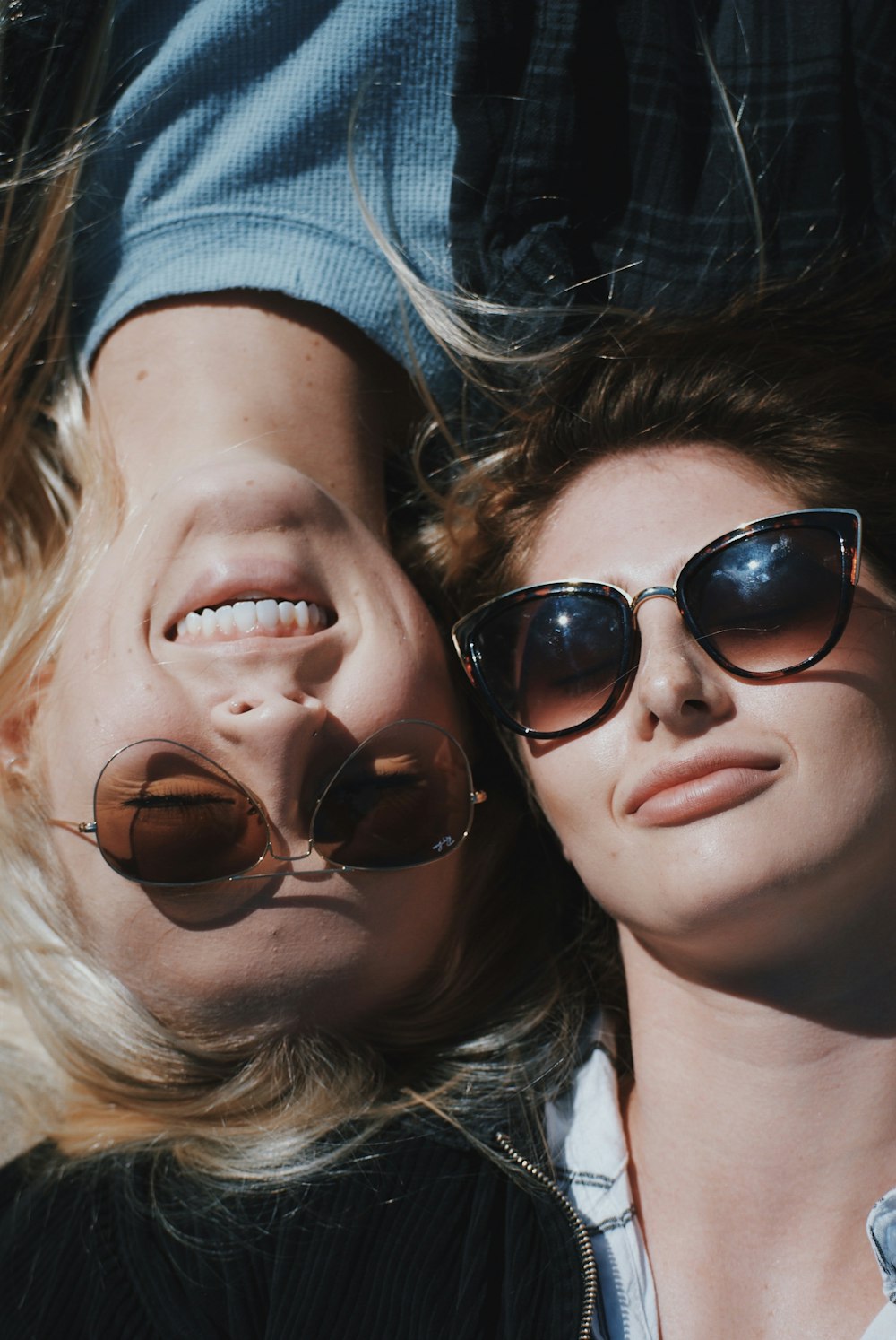Dos mujeres con gafas de sol acostadas una al lado de la otra