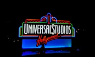 A brightly illuminated sign displaying 'Universal Studios Hollywood' in bold, neon lights. The sign features a colorful combination of red, blue, and green neon outlines against a dark background, creating a vibrant and lively appearance.