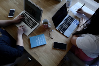 two person using laptops