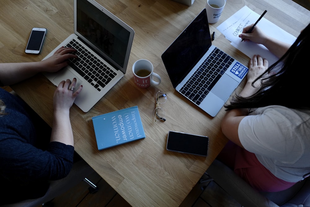 two person using laptops