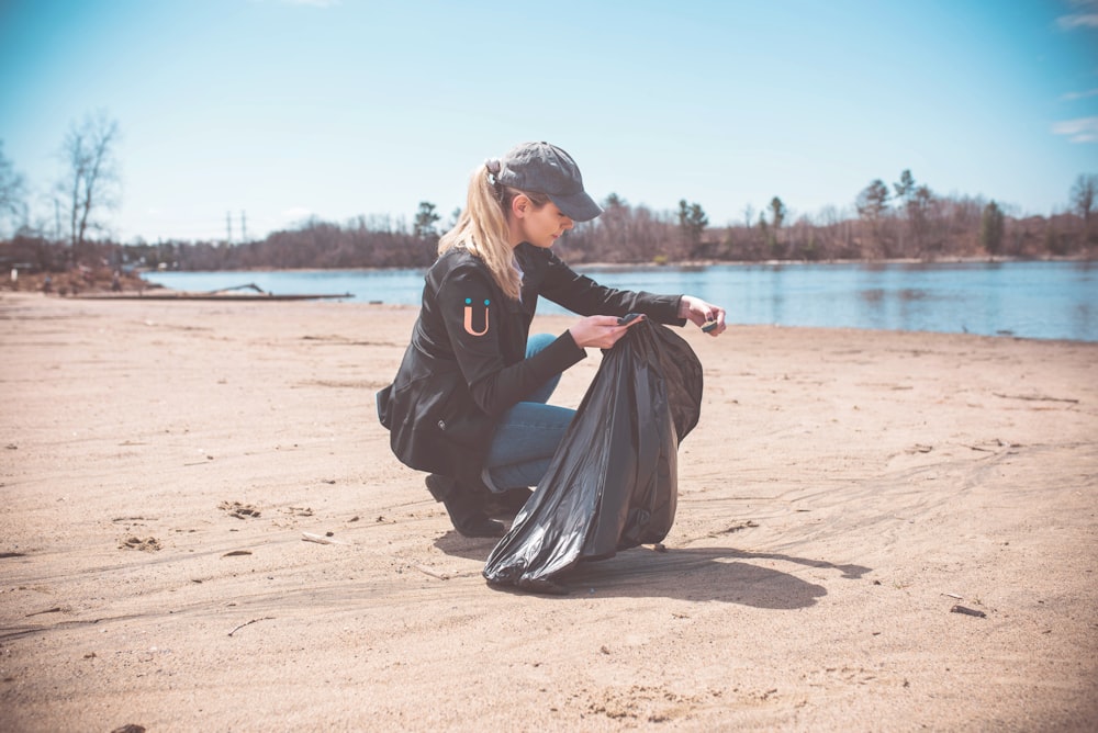 woman wearing jacket holding garbage bag