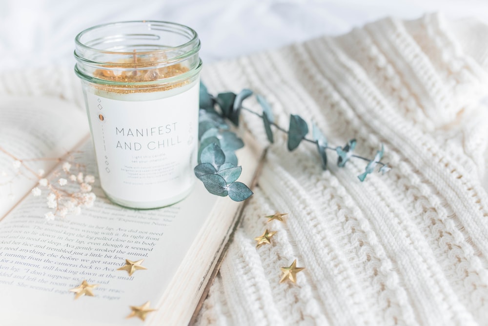 clear glass jar on opened book