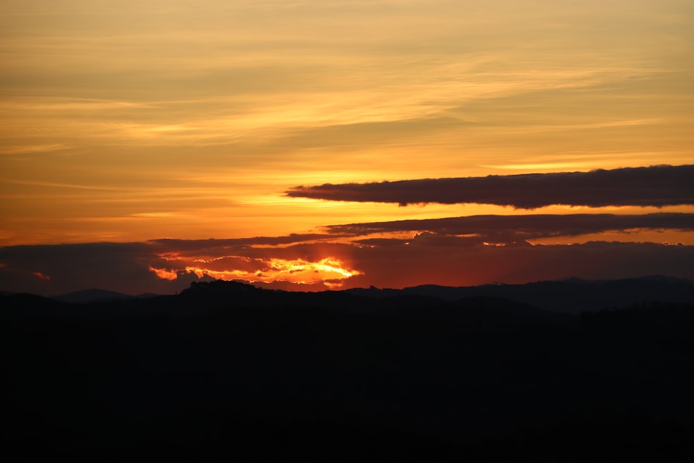 silhouette di montagna sotto cieli arancioni