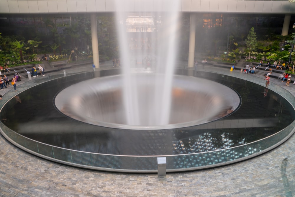 people gathering around large round water fountain