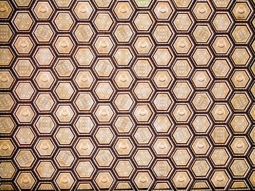 An elegant hexagonal pattern framing a serene image of the Kaaba at sunset, with deep emerald green and gold accents.