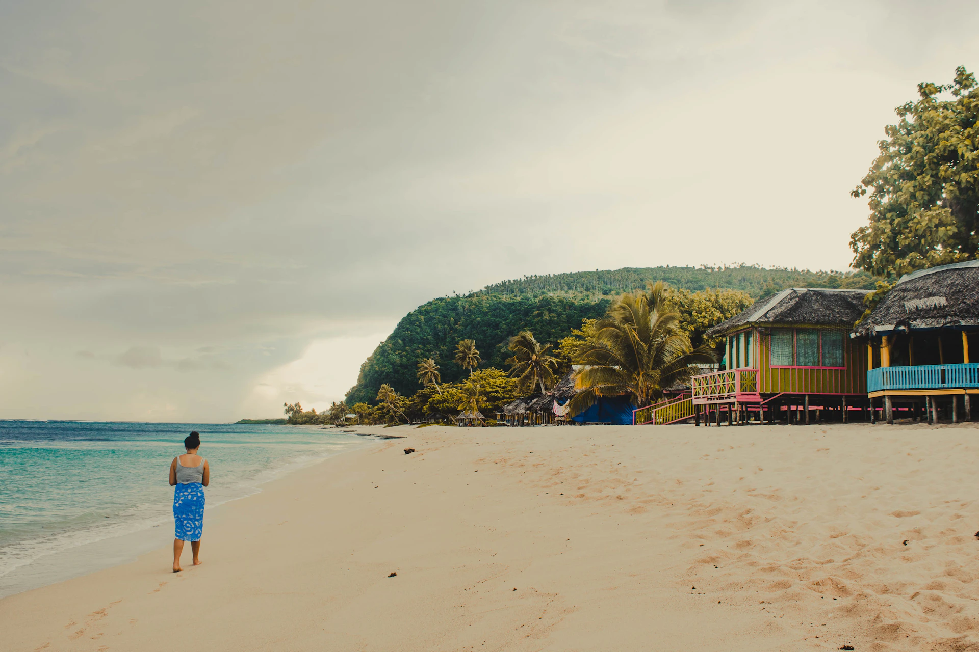 woman walking on beach shore during daytime