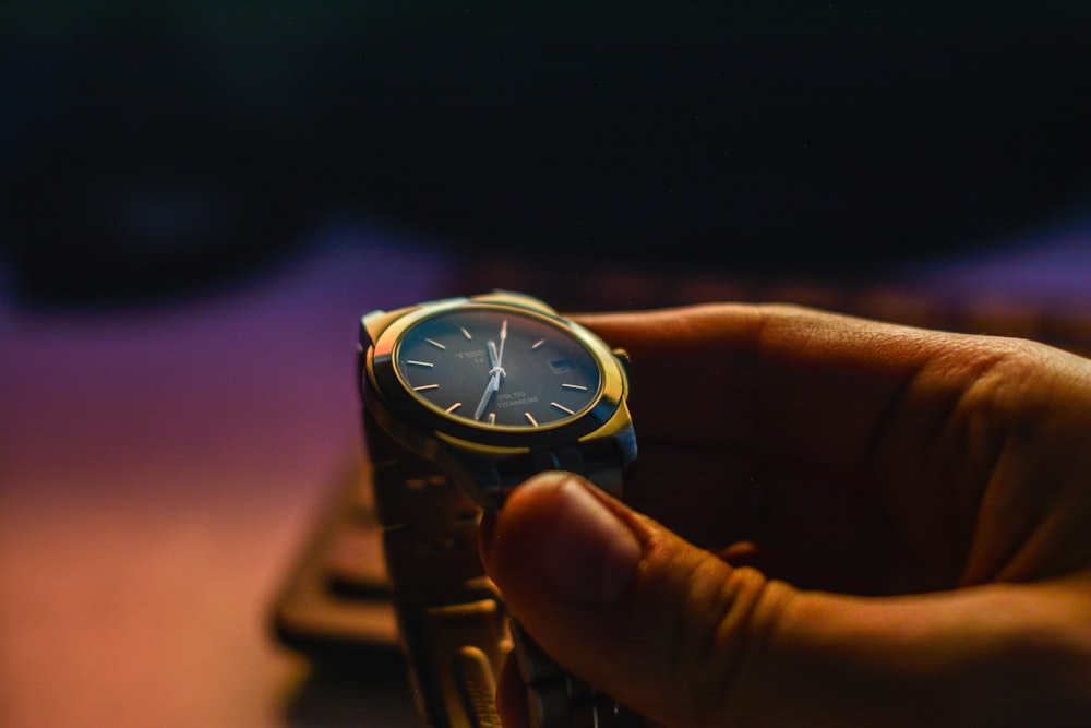 person holding silver-color analog watch