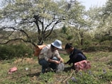 Close-up of trainees identifying local plant species with field guides in hand.