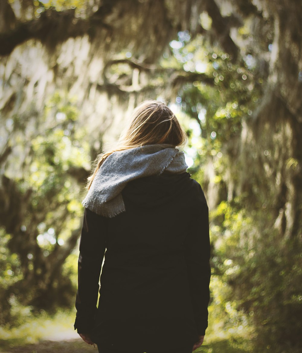 woman standing under green tree