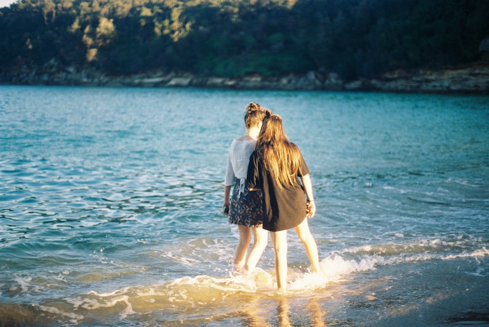 two women standing on seashore