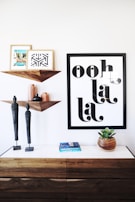 A stylish wall art display with framed prints in soft earth tones arranged above a sleek console table.