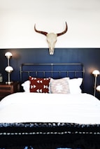 Custom steel bed frame with bold design and polished surfaces in a cozy bedroom.