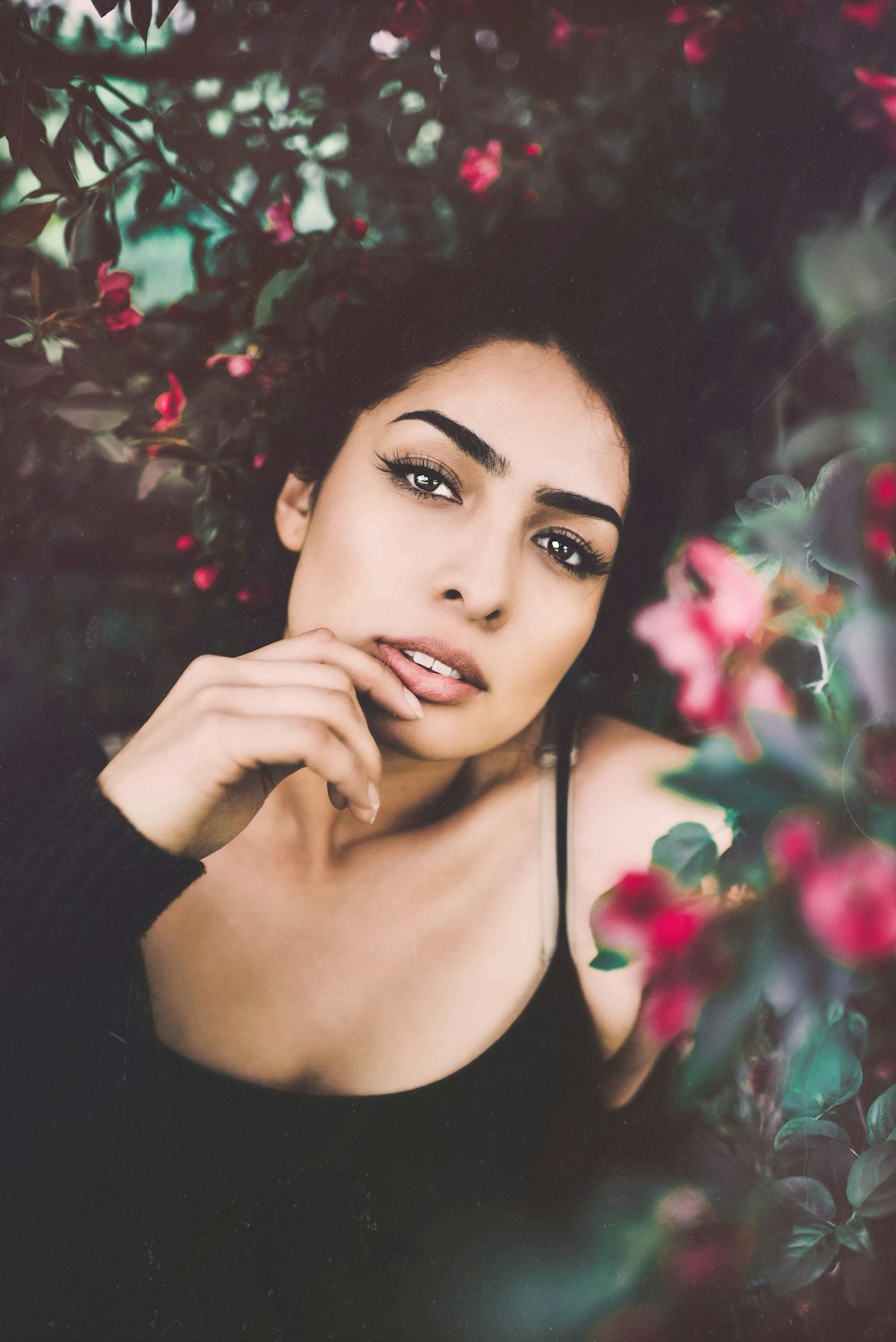 woman surrounded by red petaled flowers