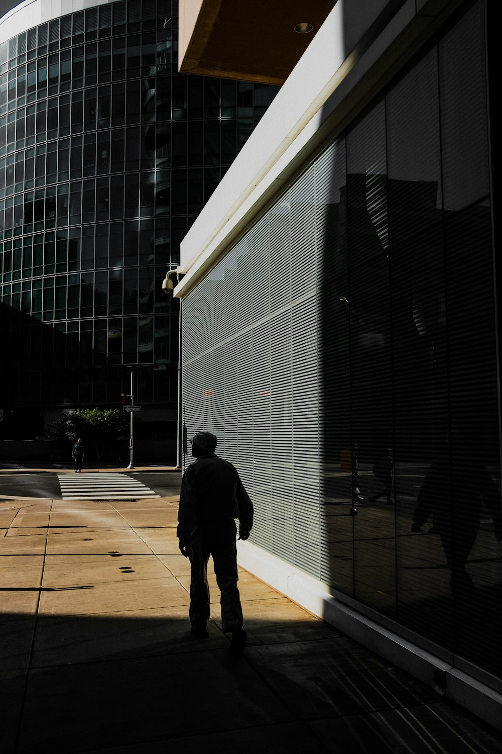 man standing beside white concrete building