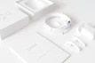 A neat arrangement of wireless earbuds and charging cases on a minimalist table.