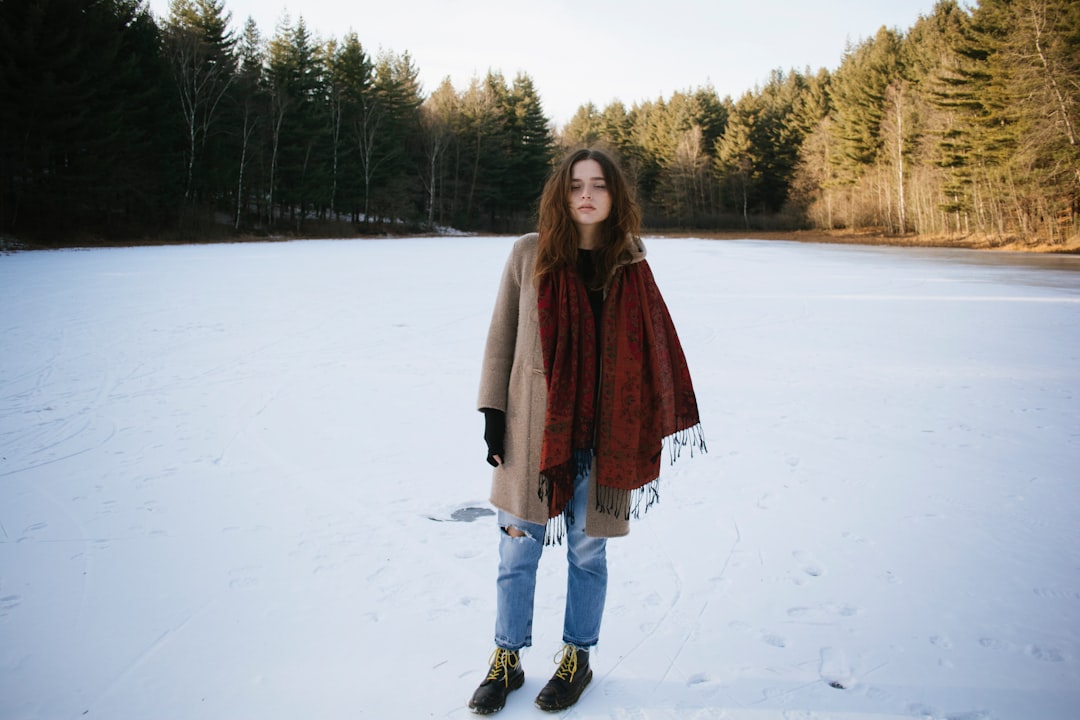 woman standing while wearing brown coat