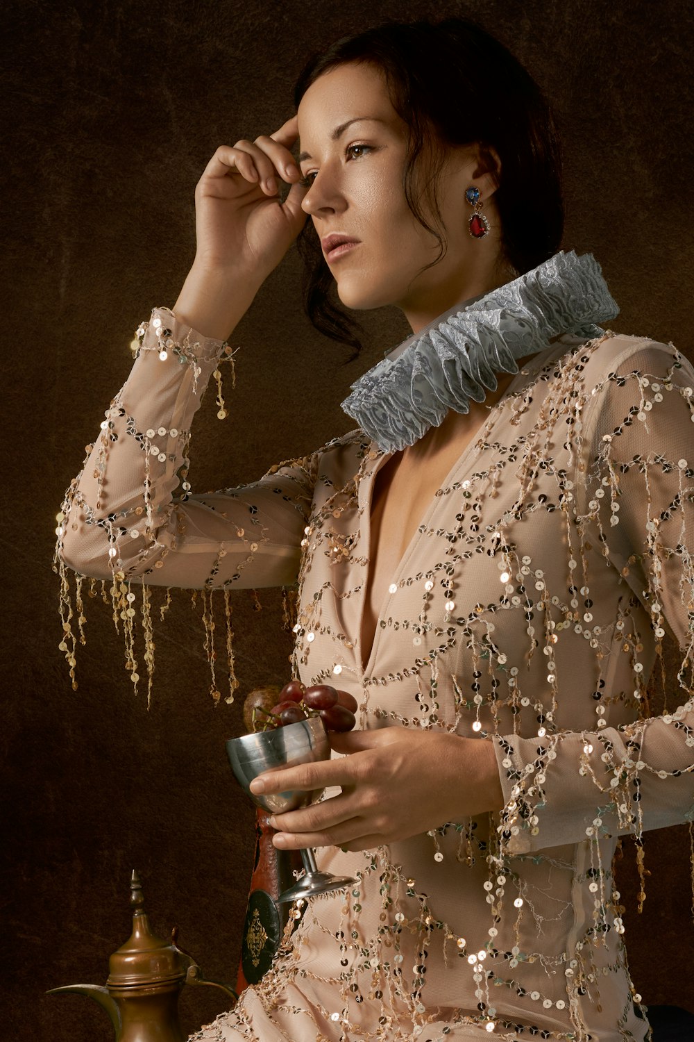 woman wearing an Elizabethan collar and carrying a chalice filled with grapes