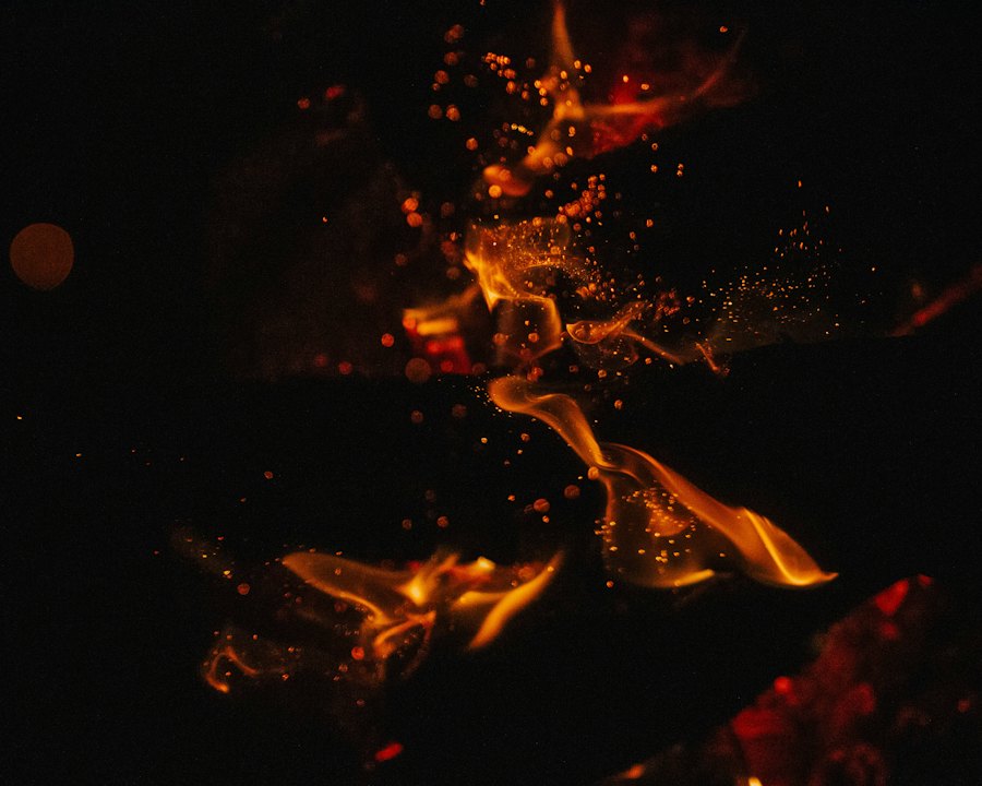 Glowing embers and sparks rising from a fire