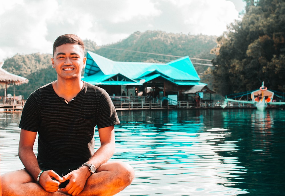 man sitting beside pool