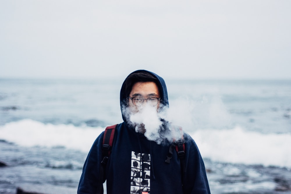 person in black hoodie smoking