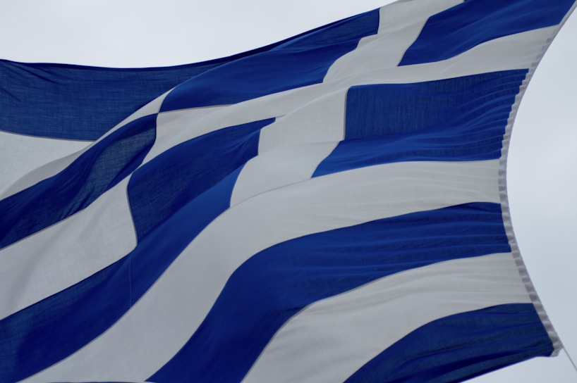 A fabric displaying alternating blue and white stripes is flowing in the wind, suggesting a flag.
