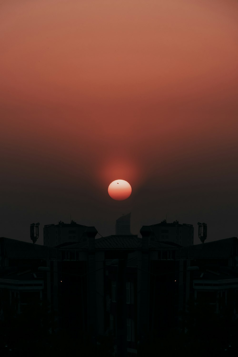 the sun is setting in the sky over a building