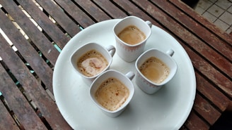 An inviting coffee tasting setup with small cups arranged neatly on a rich brown wooden tray