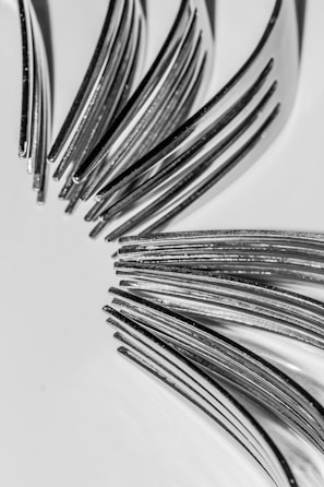 Detail of finely crafted tuning forks arranged on a natural linen cloth, highlighting their polished metal.