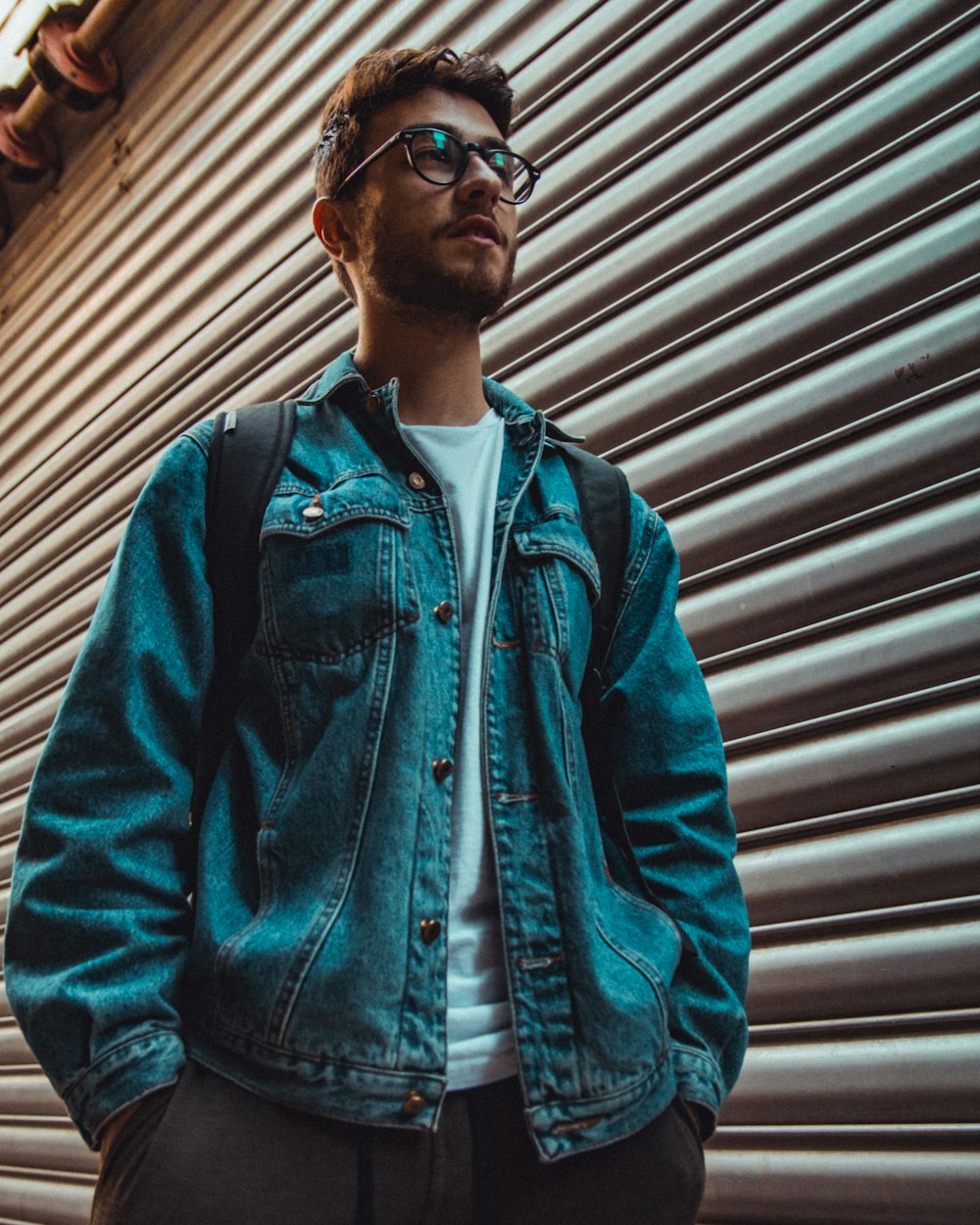 man standing beside shutter door