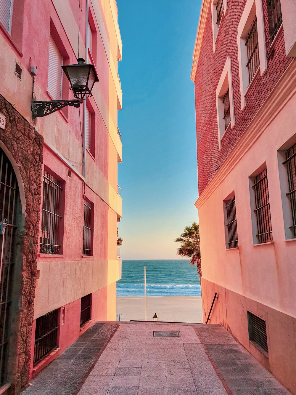 alley photography of walkway between orange building during daytime