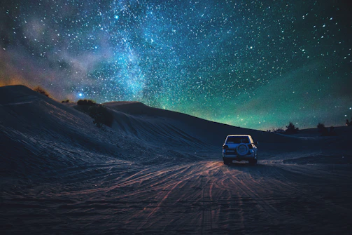 A night sky filled with stars above a 4x4 vehicle parked near a Berber village, ready for the next adventure.