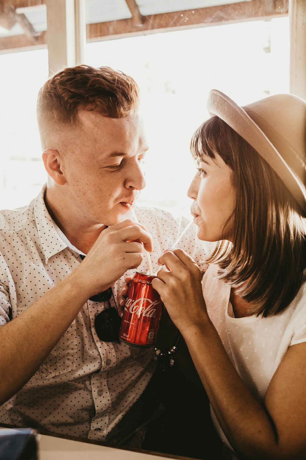 man and woman sitting near window