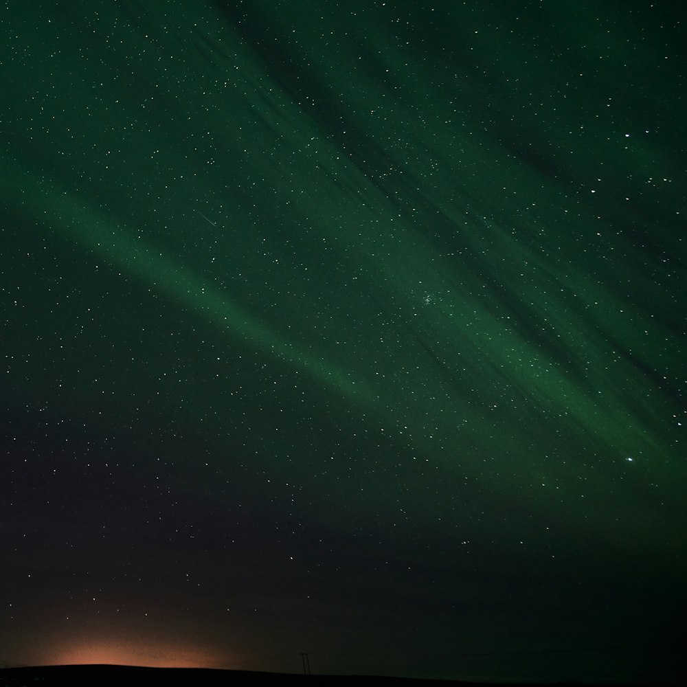 a green and black sky filled with lots of stars