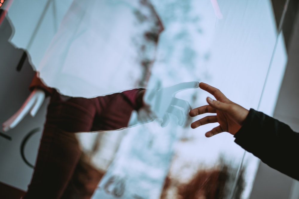 person holding glass wall