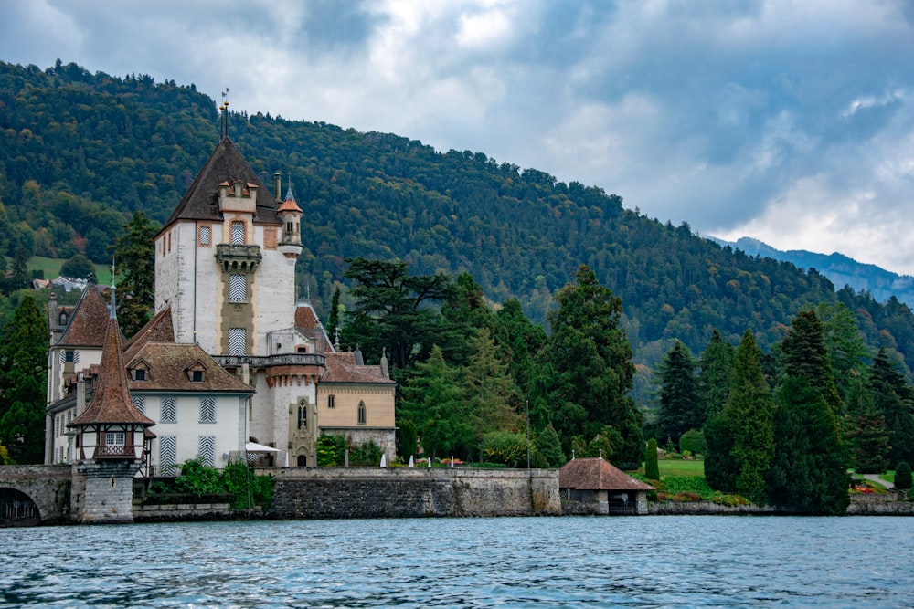 brown building near mountain and body of water