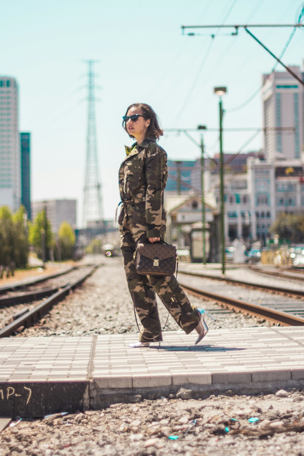 Frau in Camouflage-Soldatenuniform trägt braune 2-Wege-Ledertasche