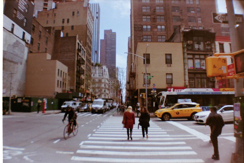 person wearing red coat crossing street during daytime