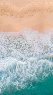 aerial photography of waves splashing on white sand beach